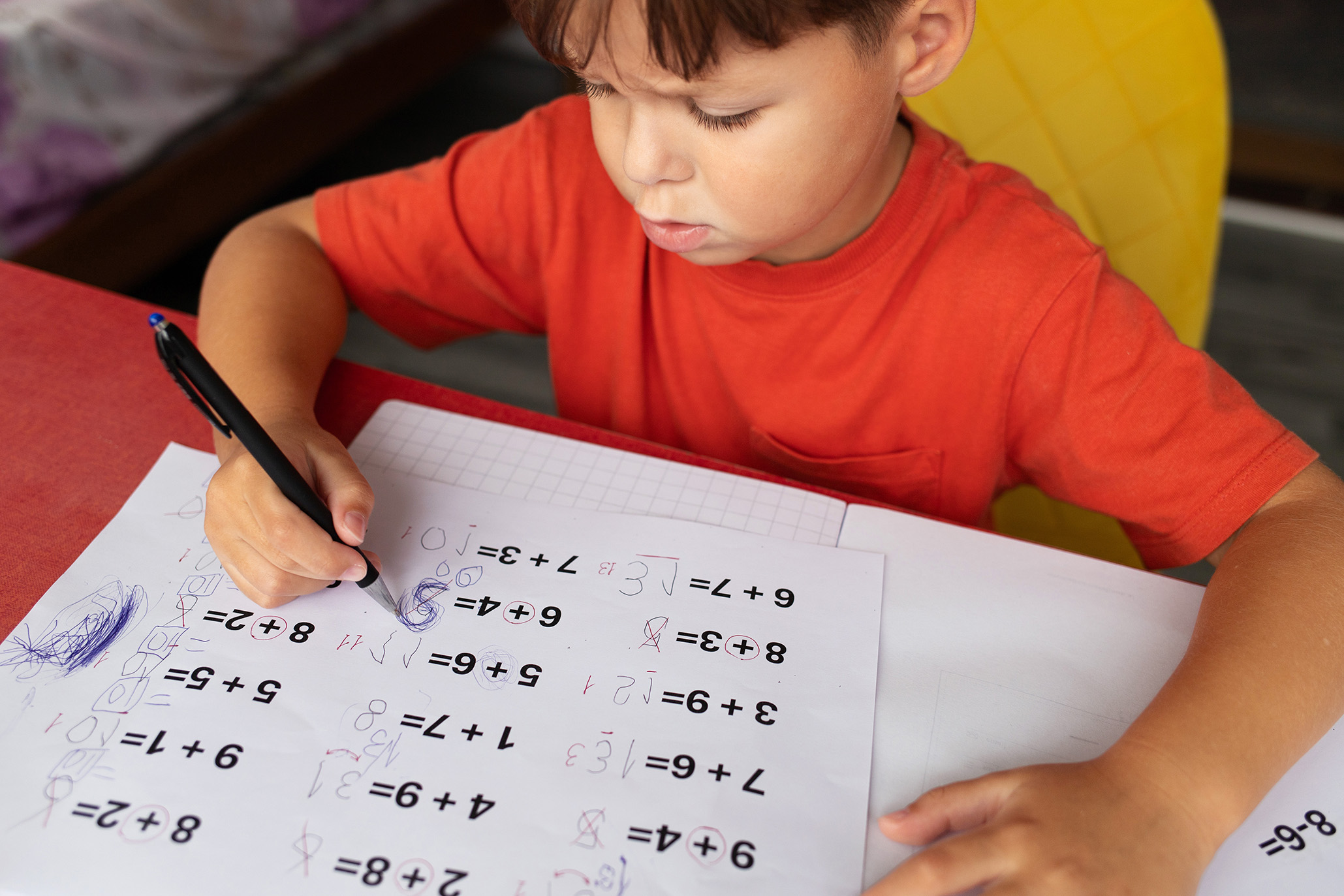 little boy with dysgraphia symptoms working on math equations and having writing difficulties